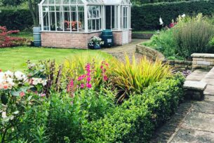  Garden design with a brick built greenhouse.