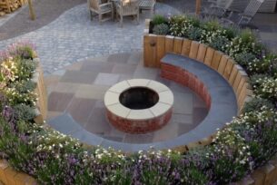  Circular garden seating using brick surrounds a fire pit.
