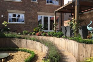  Sloped garden design using Oak sleepers and lavender planting.