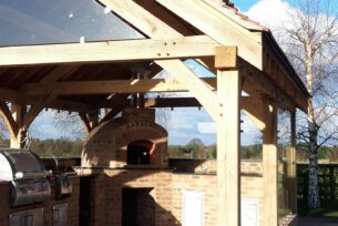  Oak built outdoor kitchen with tiled roof and lighting.