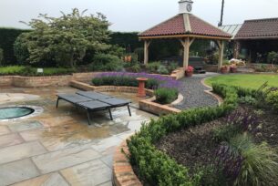 Stone paving with an Oak structure over a hot tub and natural planting create a peaceful feel.