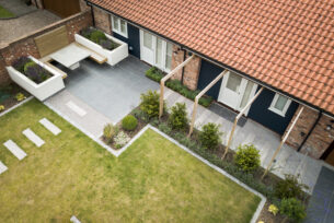  Porcelain paving with timber structure over a path to an outdoor seating area.