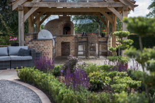  Oak building with a brick built outdoor kitchen and architectural colurfull planting.