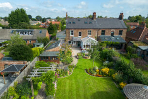  Aerial view of a rear garden showing a timber pergola walk-through, natural lawn and natural planting design.