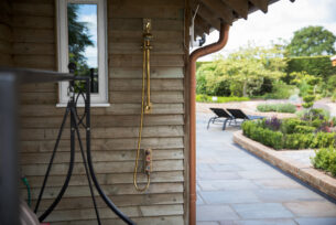  Garden design incorporating a dog shower against a timber wall.
