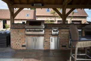  Stainless steel outdoor kitchen components on a granite worktop and brickwork.