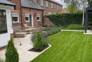  Modern garden design using porcelain paving and lavender planting with a natural lawn and metal pergola.