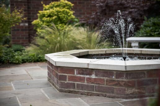 Brick built octagonal pond with fountain set in formal gardens in York