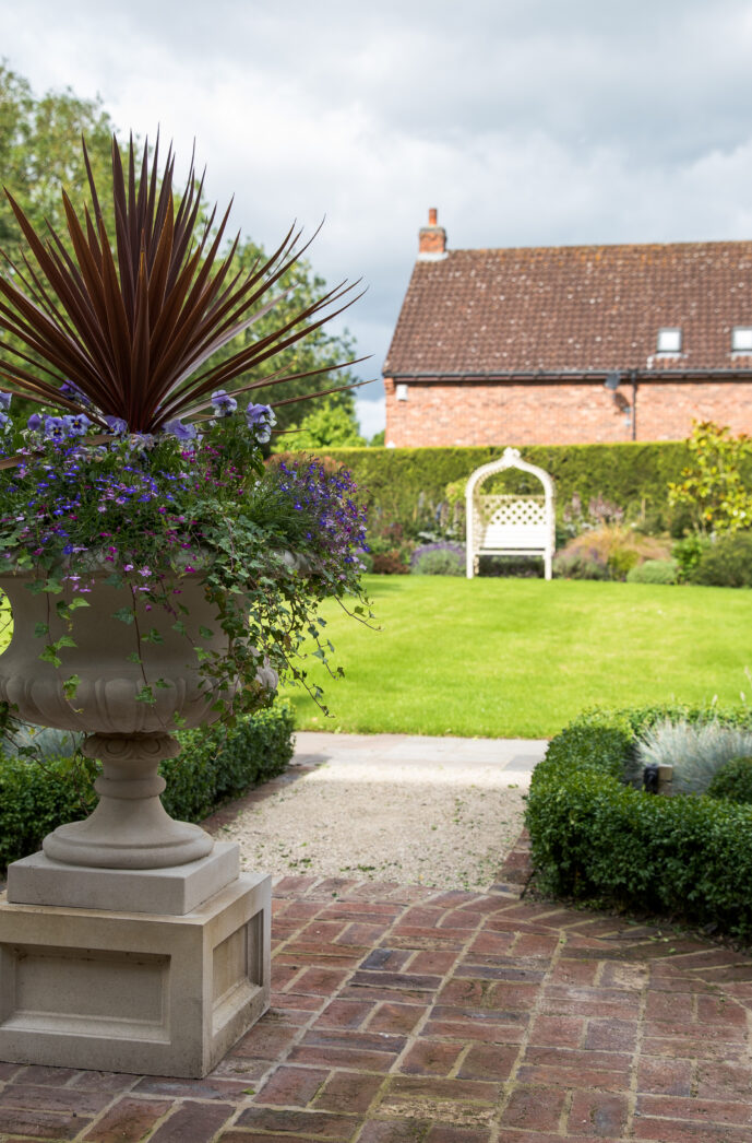 Large Formal garden in Acaster Malbis York with handmade brick pavers and stone urn